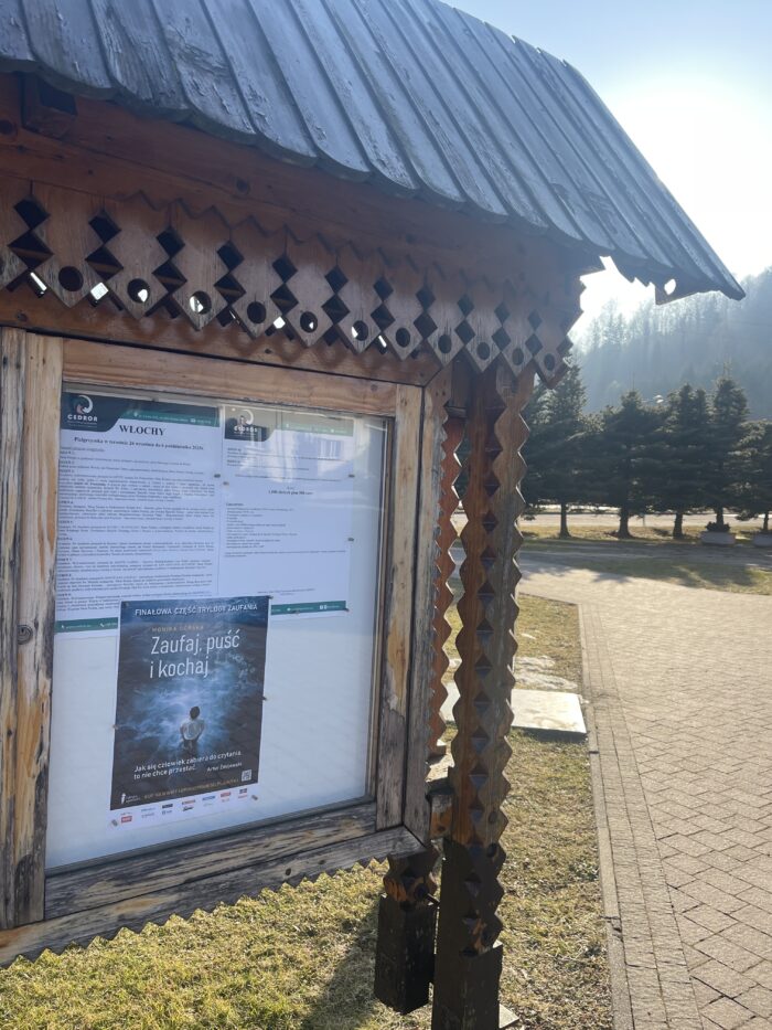 Plakat wybitnej książki Zaufaj puść i kochaj na tablicy ogoszeń